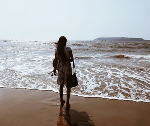 Rear view of woman standing on beach