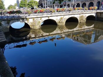 Arch bridge over river against sky