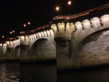 Illuminated bridge over river at night