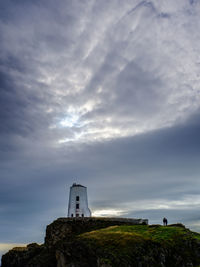 Lighthouse by sea against sky