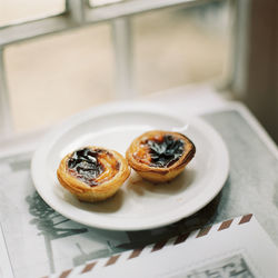 Close-up of portuguese custard tarts on plate on table