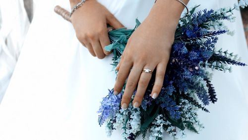 Midsection of bride holding flower bouquet