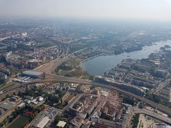 High angle view of city by river against sky