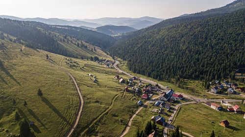 Aerial view of village by mountains 