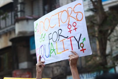 Close-up of cropped hands holding sign