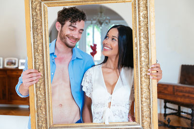 Smiling couple holding frame border