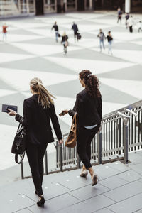 Businesswomen moving down staircase