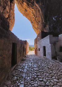 Footpath amidst old buildings against sky