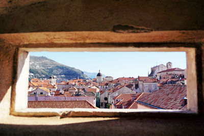 Townscape seen through window against sky