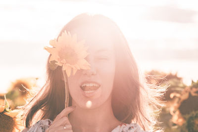 Portrait of smiling young woman against sky