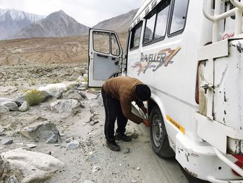 Man repairing motor home on road