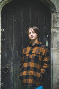 Young woman standing against wall