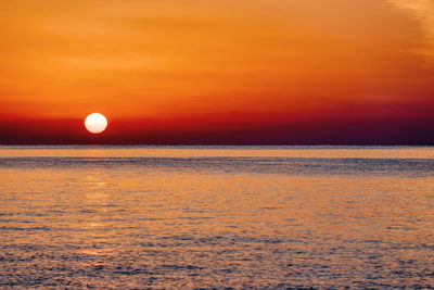 Scenic view of sea against orange sky