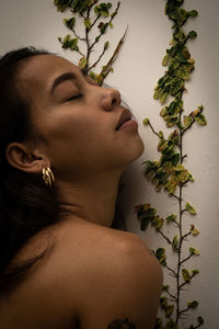 Close-up portrait of woman against wall