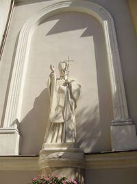 Low angle view of statue against window