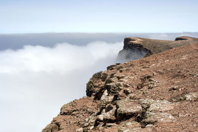 Rock formations in sea against sky