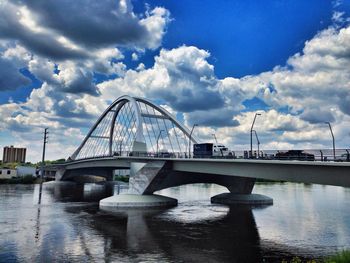 Bridge over river against cloudy sky