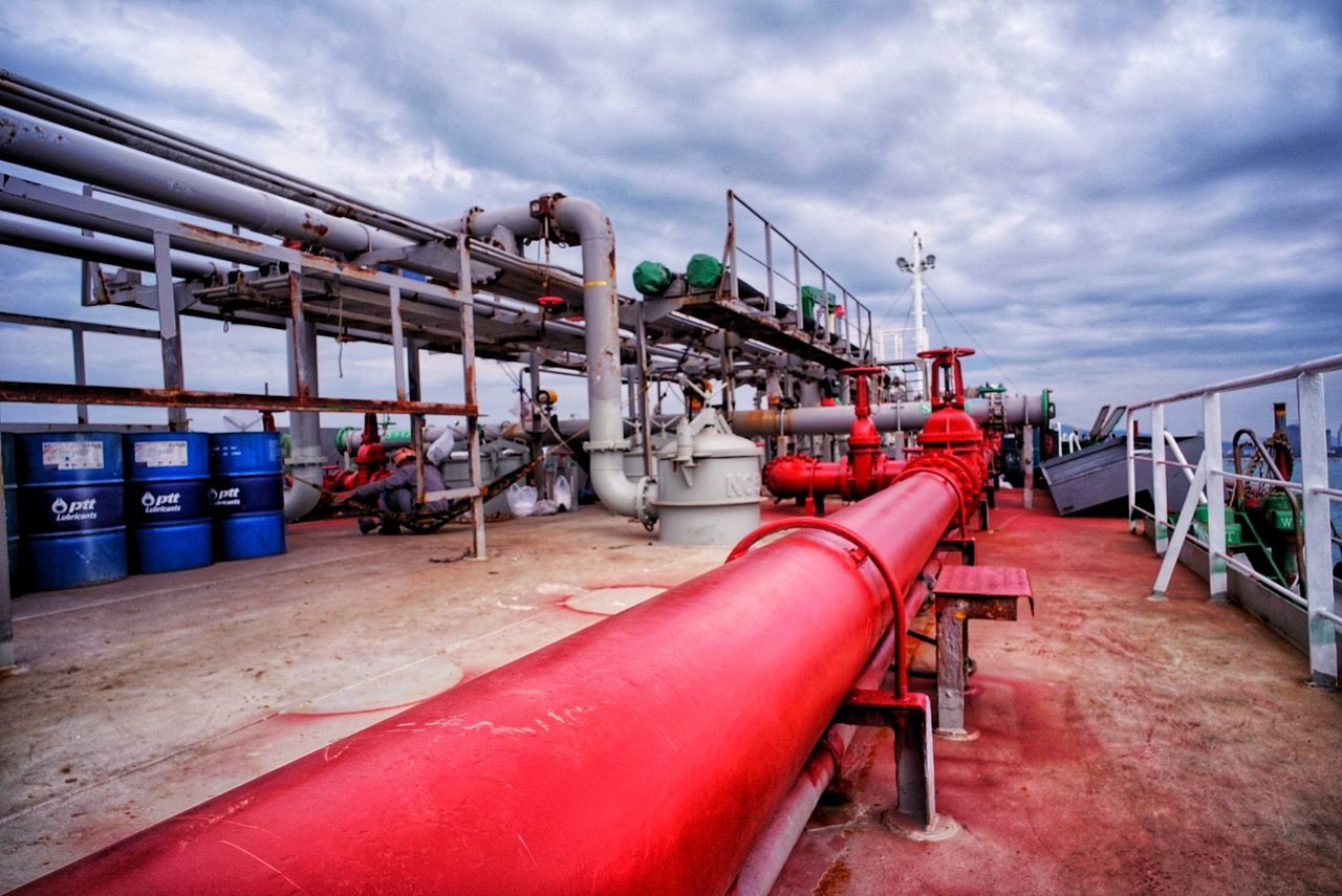 cloud - sky, sky, nature, industry, day, built structure, water, pipe - tube, connection, architecture, outdoors, transportation, red, incidental people, factory, bridge, nautical vessel, pier, railing