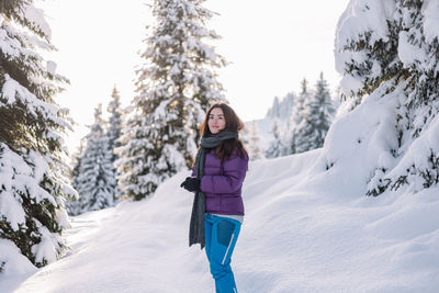 Rear view of woman standing on snow covered field