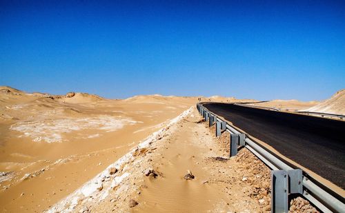Scenic view of desert against clear blue sky