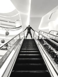 Low angle view of man standing on escalator