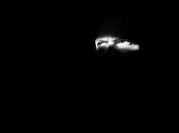 Close-up portrait of young woman in darkroom