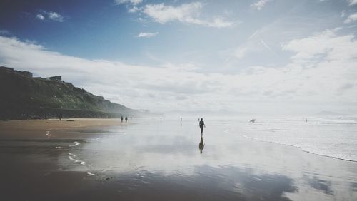 Man standing on beach against sky