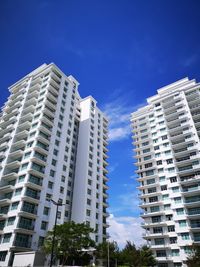 Low angle view of modern buildings against blue sky