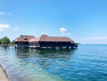 House by sea against blue sky