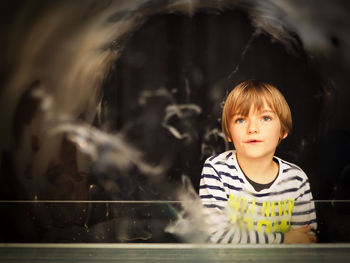 Boy playing with bubbles standing at railing