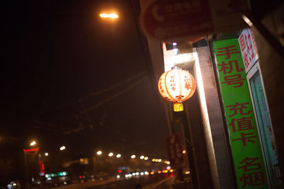 Low angle view of illuminated information sign at night