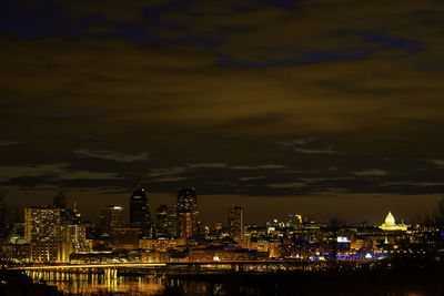 Illuminated cityscape against sky at night