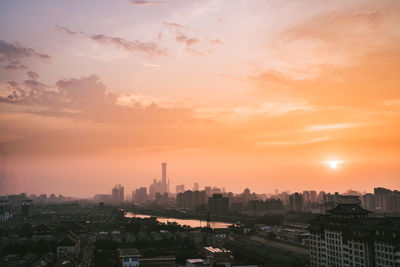 High angle view of cityscape against cloudy sky during sunset