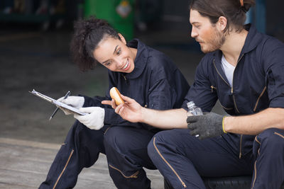 Happy couple taking their car for service and waiting relax time at garage