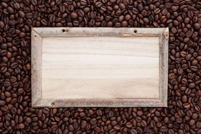 High angle view of wooden plank on roasted coffee beans