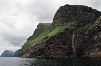 Low angle view of rock formation against cloudy sky