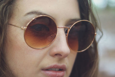 Close-up portrait of beautiful young woman wearing sunglasses