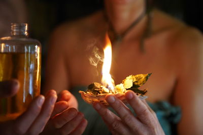 Close-up of woman holding burning candles