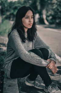 Portrait of young woman sitting outdoors