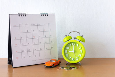 Close-up of clock on table against wall
