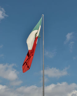 Low angle view of flag waving against sky