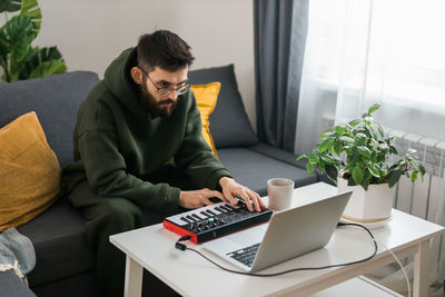 Young man using laptop while sitting on table at home