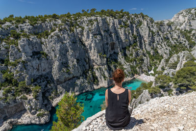 Rear view of woman standing on rock