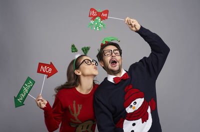 Young man and woman standing against gray background