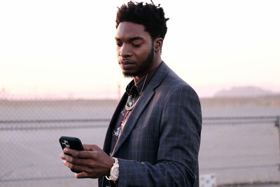African american business man checking phone at sunset