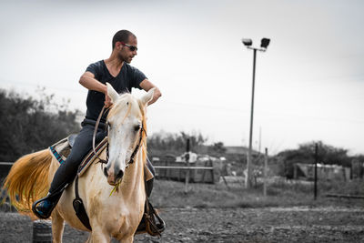 Full length of man riding horse on field