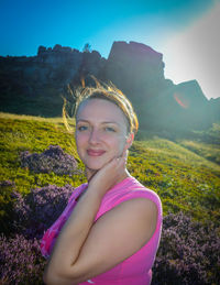 Close-up portrait of young woman smiling against mountains