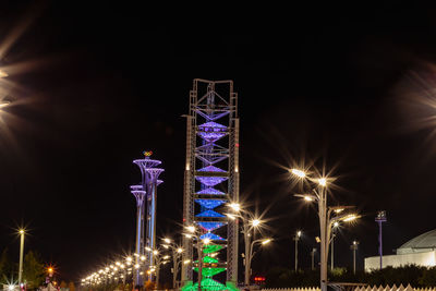 Low angle view of illuminated city against sky at night