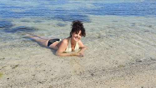 Low section of woman standing at beach