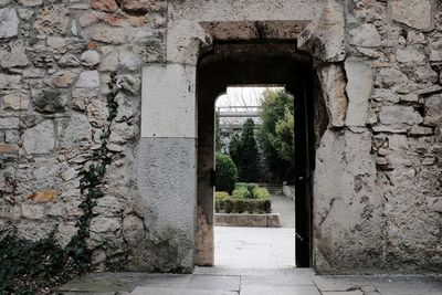 Narrow walkway along brick wall